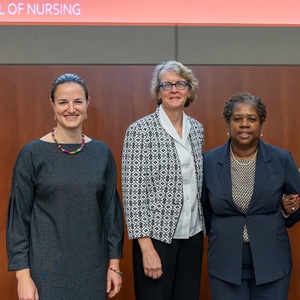 Four people stand together at the front of a lecture hall